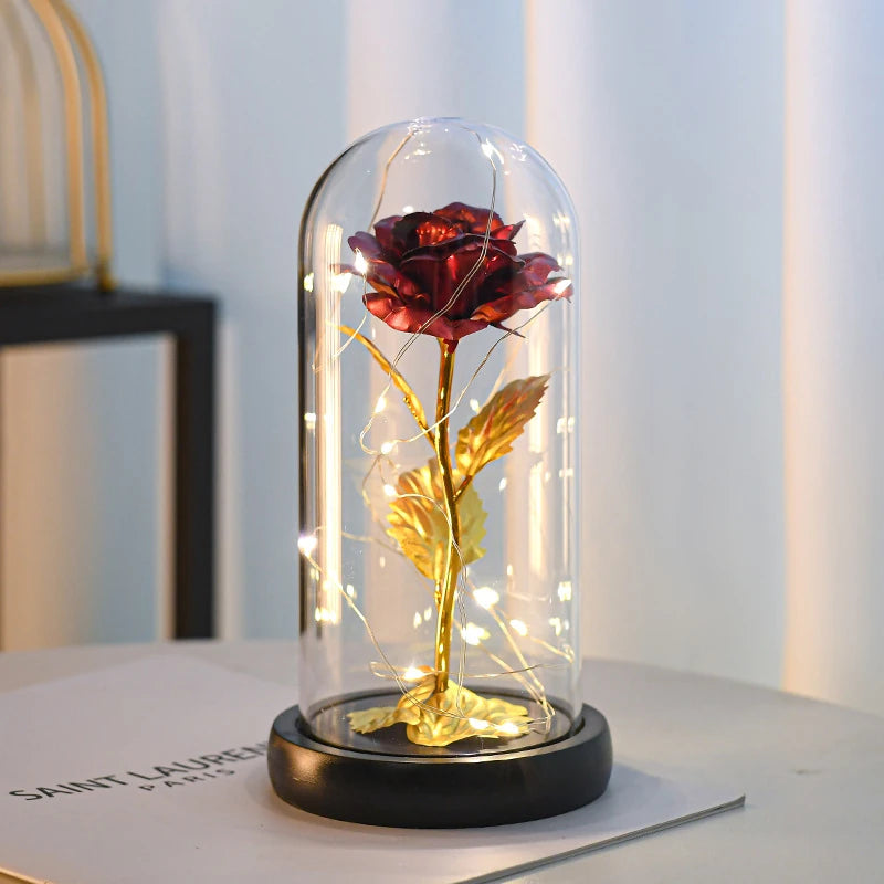 Forever Rose in red, lit under its clear dome