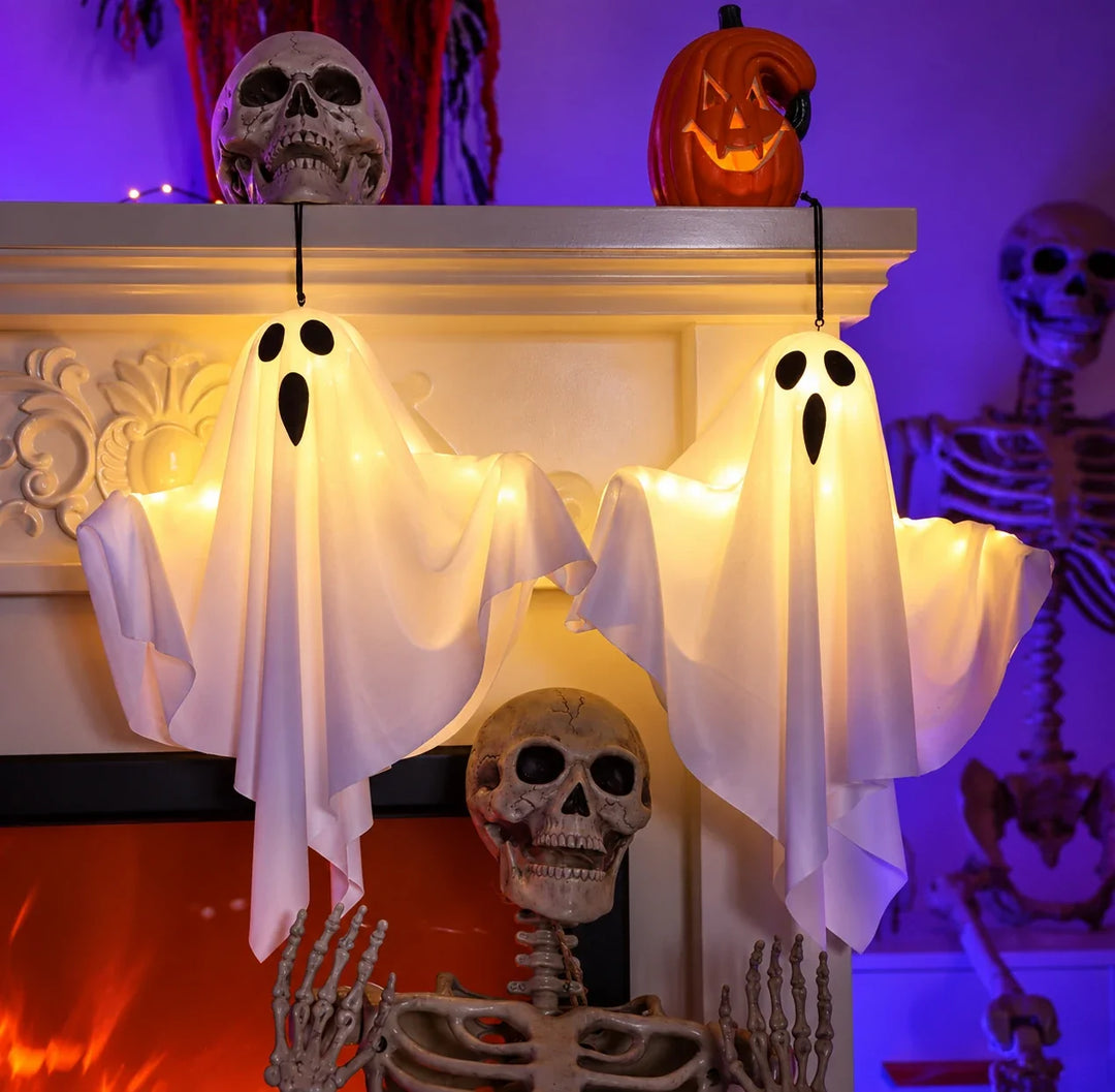 Los dos Ghost Lights del pack colgados de la repisa de una chimenea decorada de Halloween
