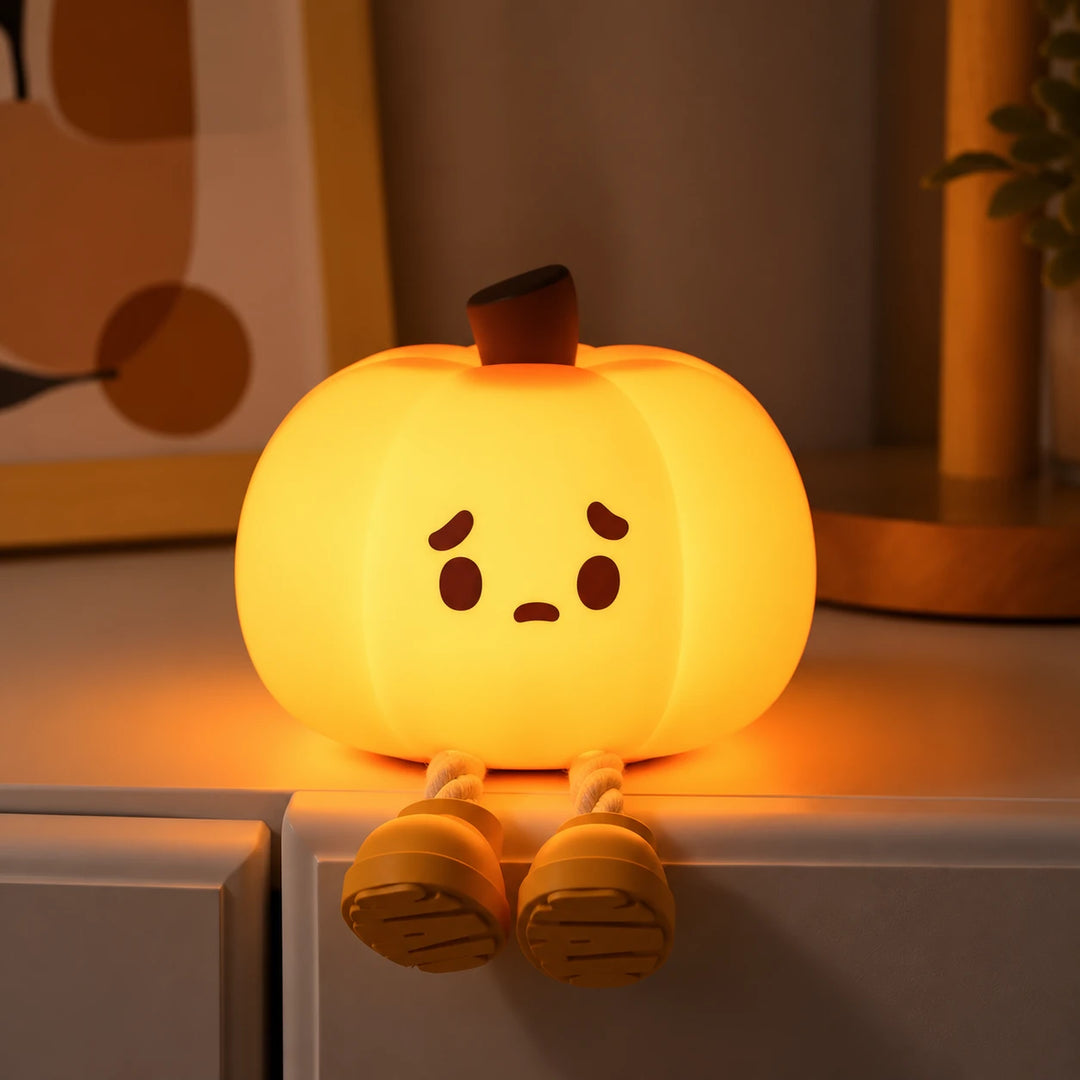 La Pumpkin Lume encendida en el borde de una repisa, con las piernecitas colgando