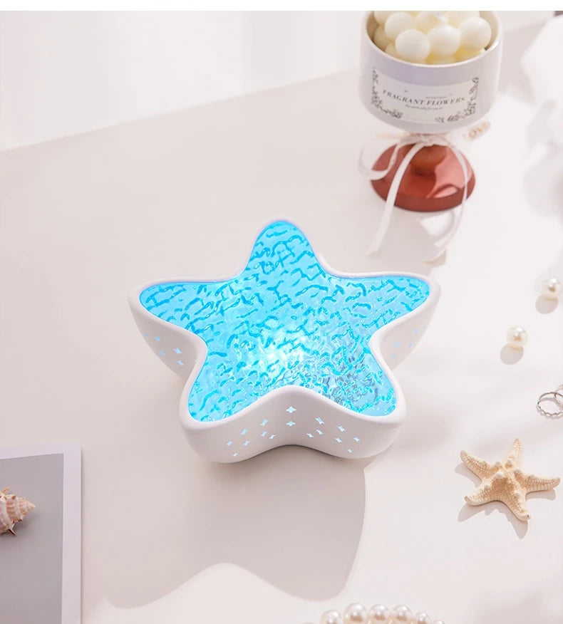 Starfish Lume on a white table in daylight, next to seashells