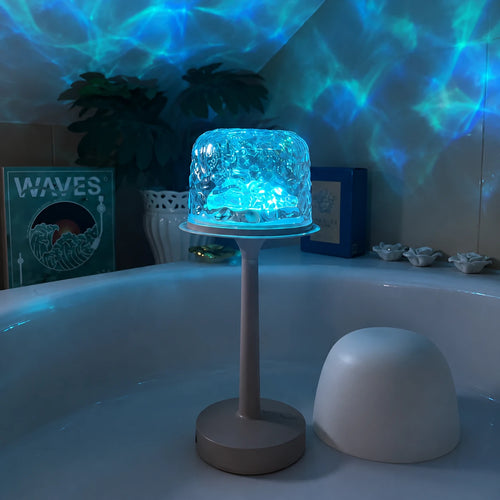 Tide Lume lit in blue, spreading water ripples across the wall behind it