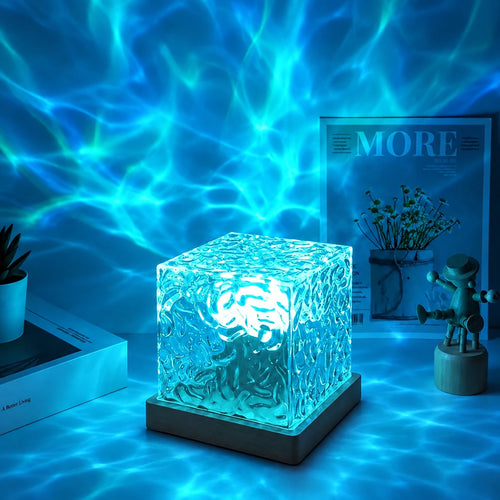 Wave Lume lit in blue on a desk, ripples spreading across the wall behind it
