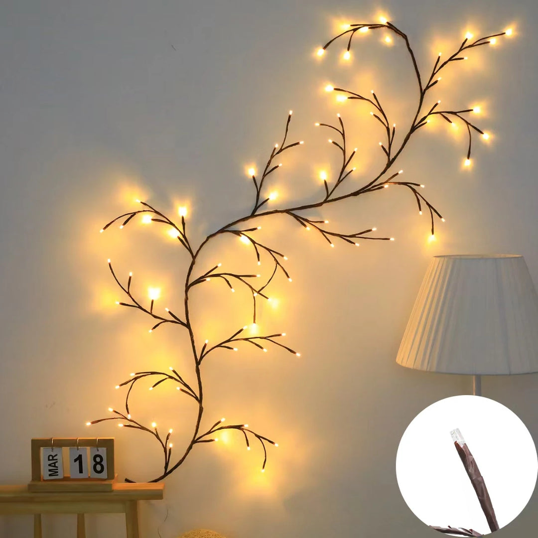 Willow Lights lit up in warm white, a bare vine climbing a wall next to a lamp
